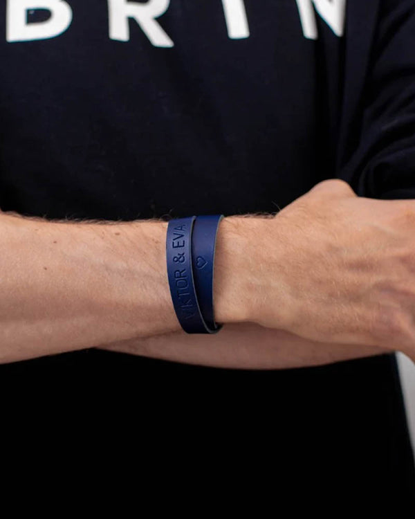 DUO læderarmbånd i mørkeblåt læder med graveringen "Viktor & Eva" ♡ om håndleddet, sort t-shirt