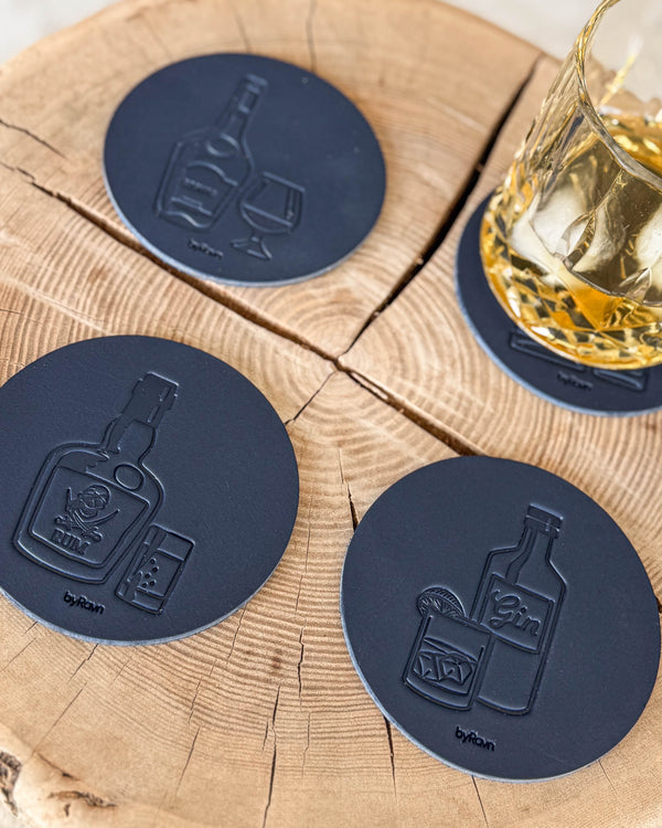 MOKKA spiritus bordskånere i mørkeblåt læder præget med cognac, rom og gin på træskive ved krystalglas med whisky og is