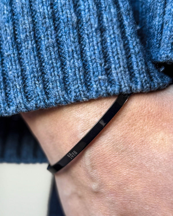 VENUS STICK armbånd i sort stål med tændstikfamilie graveret om håndleddet, blå ribstrik