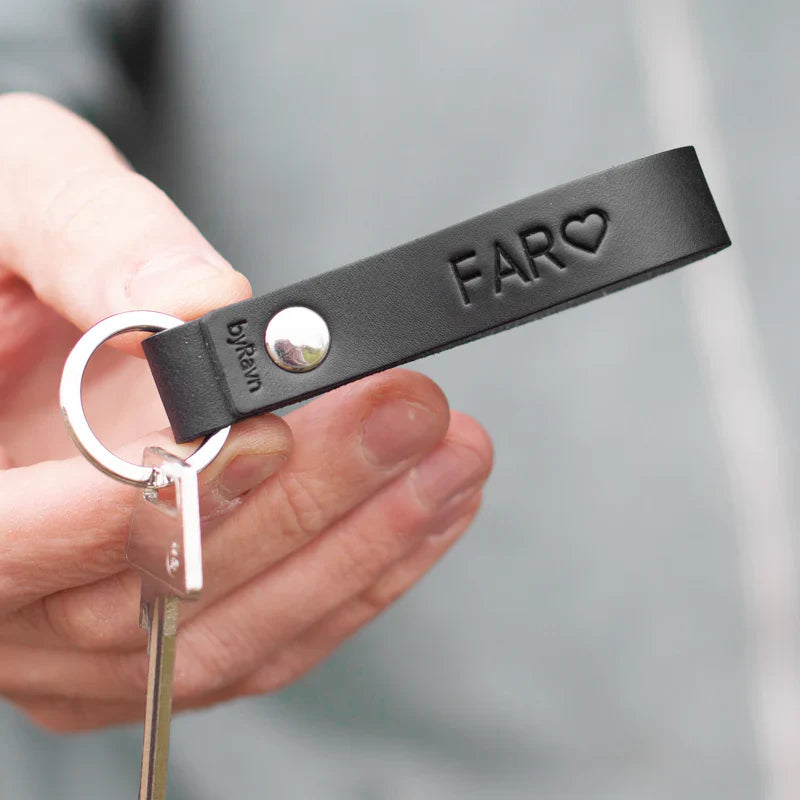 Julegave til ham – RAVN nøglering i sort læder med "Far" ♡ præget og nøgle, holdt frem i hånden