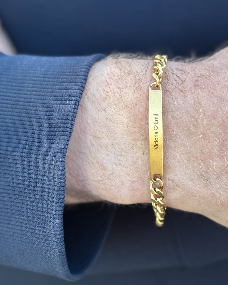 ARA armbånd i børstet guldbelagt stål med personlig gravering "Victoria ♡ Emil" om mandens håndled