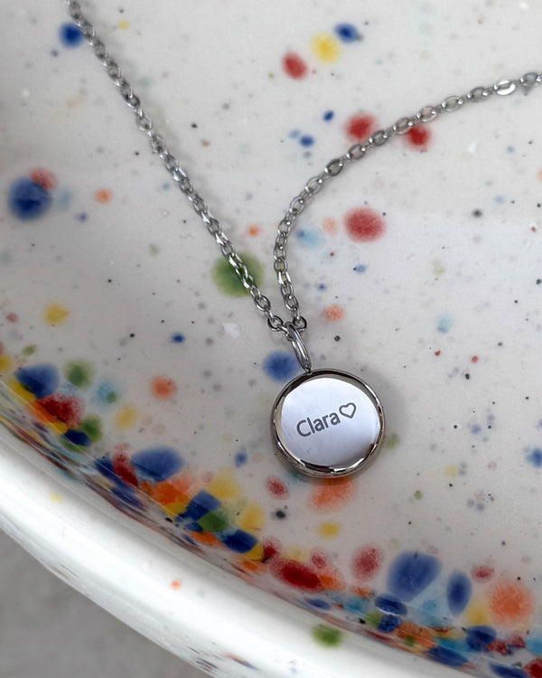 AYA NOTE navnehalskæde i sølvfarvet rustfrit stål med navnet "Clara" ♡ graveret på lille vedhæng, på spættet keramikfad