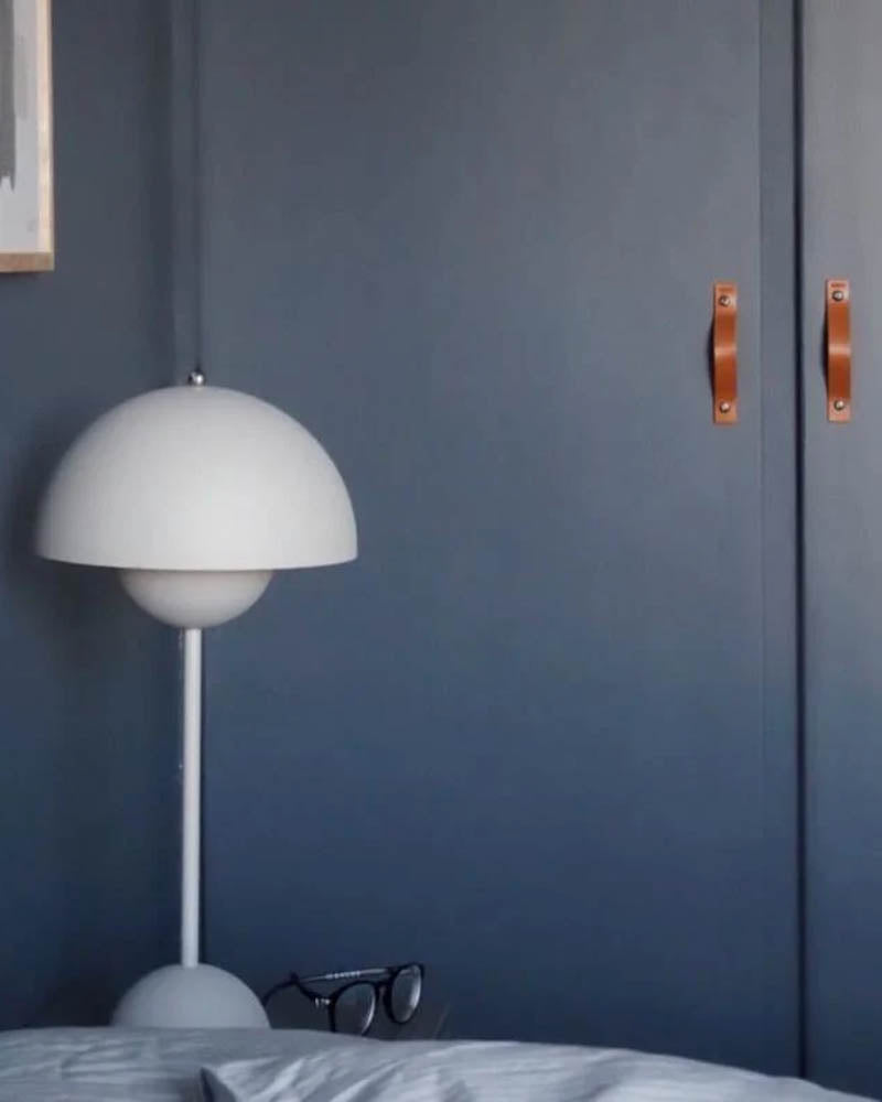 BAND greb i cognac læder på to mørkeblå skabslåger i soveværelse med hvid Flowerpot-lampe