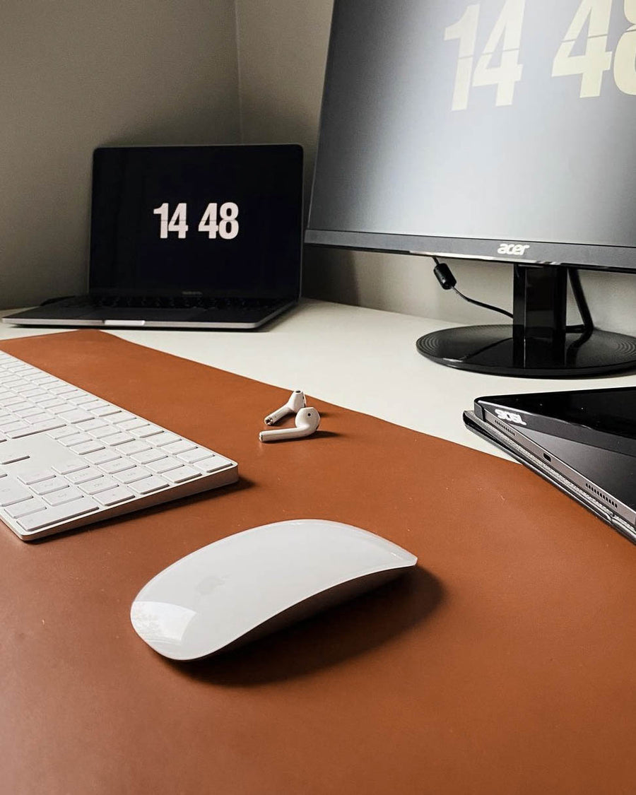 DESK skriveunderlag i cognac læder på skrivebord med tastatur, mus, øretelefoner, laptop og skærm