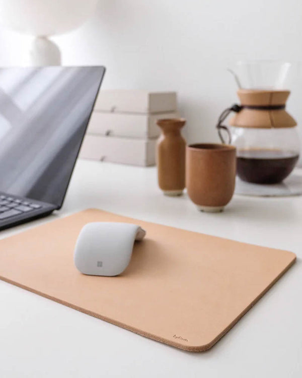 DOS musemåtte i naturfarvet kernelæder på skrivebord med laptop, mus, kaffekande og keramikkop