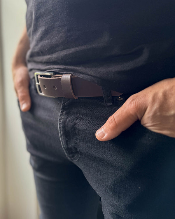EDGE bælte i mørkebrunt læder båret i sorte jeans med sort t-shirt og hånden i lommen