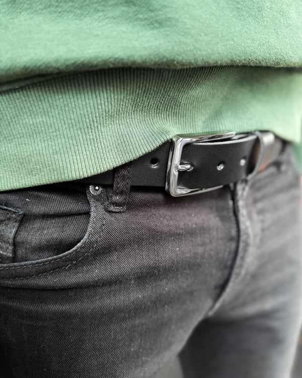 EDGE bælte i sort læder med sølvfarvet stålspænde båret i sorte jeans med grøn sweatshirt
