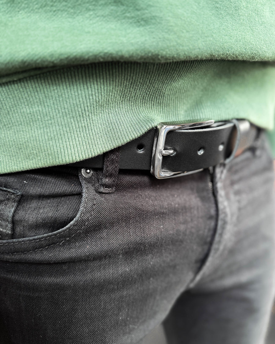 EDGE bælte i sort læder med sølvfarvet stålspænde båret i sorte jeans med grøn sweatshirt