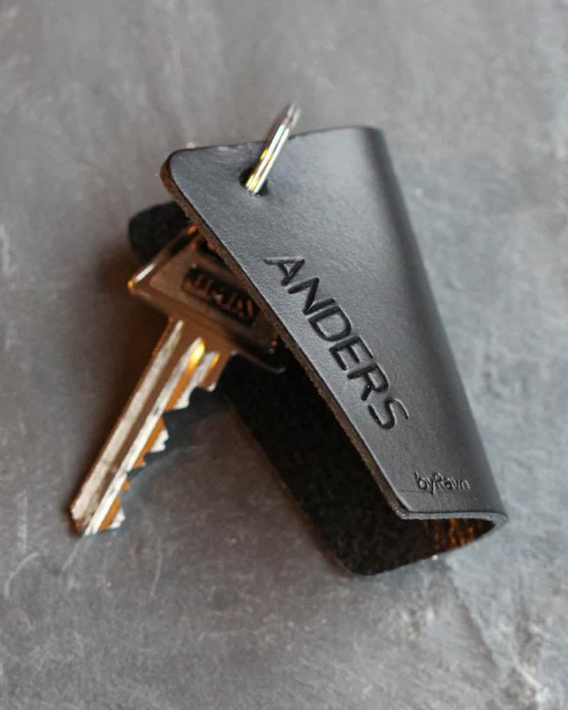 FOLD nøgleskjuler i sort læder med navnet "Anders" graveret, med nøgler på mørk skifer