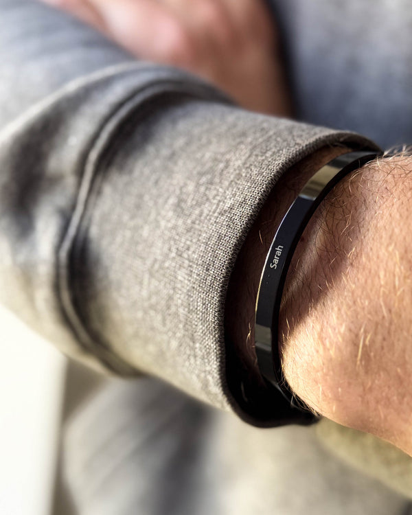 MARS armbånd i sort stål med navnet "Sarah" graveret om mandehåndled, grå sweatshirt