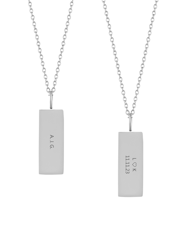 MIO halskæde fra byRavn i sølvfarvet rustfrit stål, to rektangulære vedhæng med initialerne "A.J.G." og "L ♡ K 11.11.23" graveret