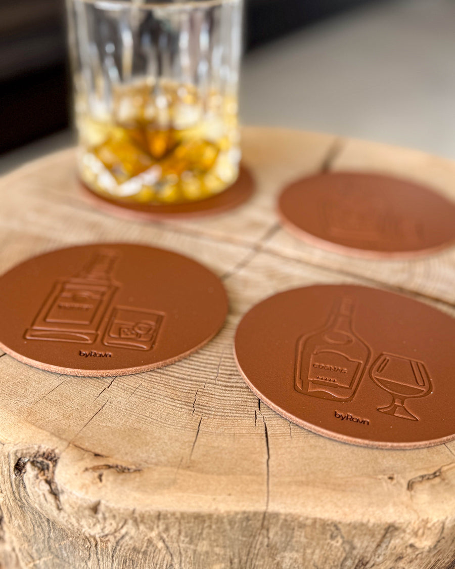 MOKKA spiritus bordskånere i cognac læder præget med whisky og cognac på træskive ved krystalglas med whisky og is