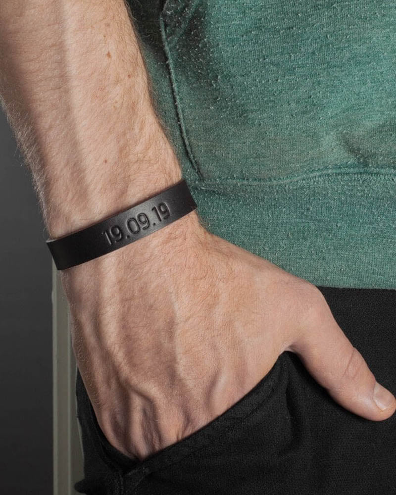 MONO læderarmbånd i mørkebrunt læder med datoen "19.09.19" graveret om mandehåndled, grøn t-shirt