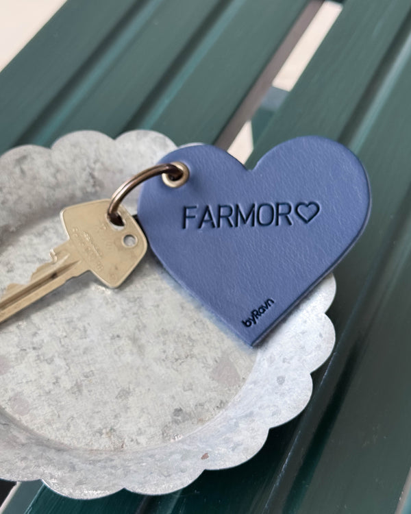 ROSE hjerte-nøglering i mørkeblåt læder med graveringen "Farmor" ♡ og nøgle i zinkskål på grøn træbænk