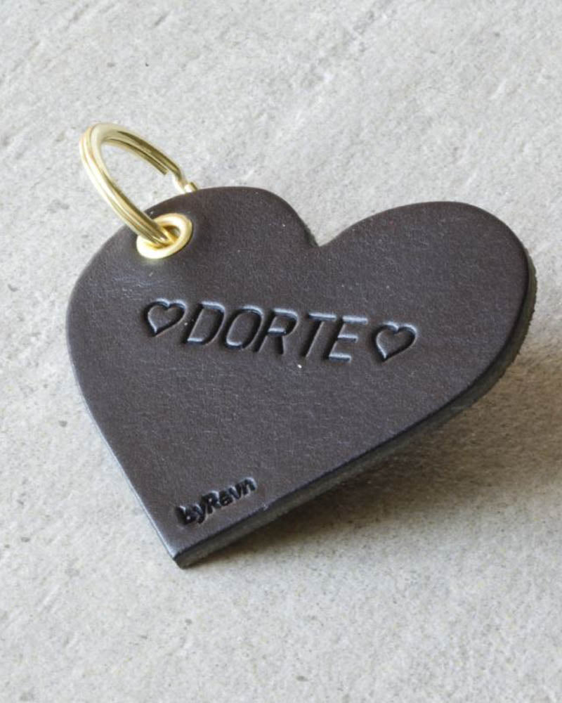 ROSE hjerte-nøglering i sort læder med personlig gravering ♡ "Dorte" ♡ og gylden nøglering på lys betonbaggrund