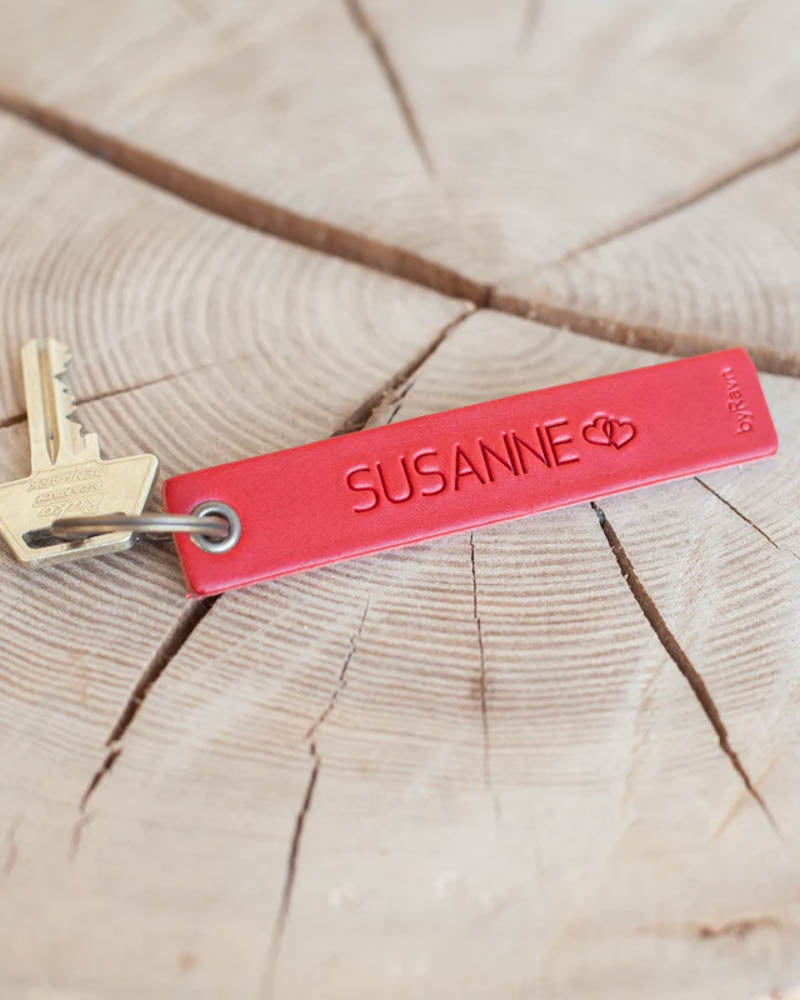 SOLO Medium nøglering i rødt læder med navnet "Susanne" og to hjerter graveret, med nøgle på træskive