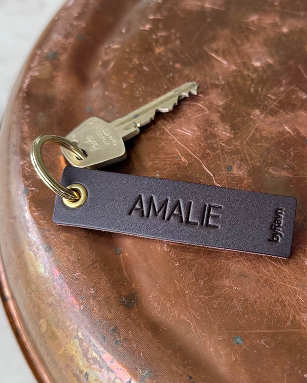 SOLO Small nøglering i mørkebrunt læder med navnet "Amalie" graveret, gylden ring og nøgle på kobberbakke