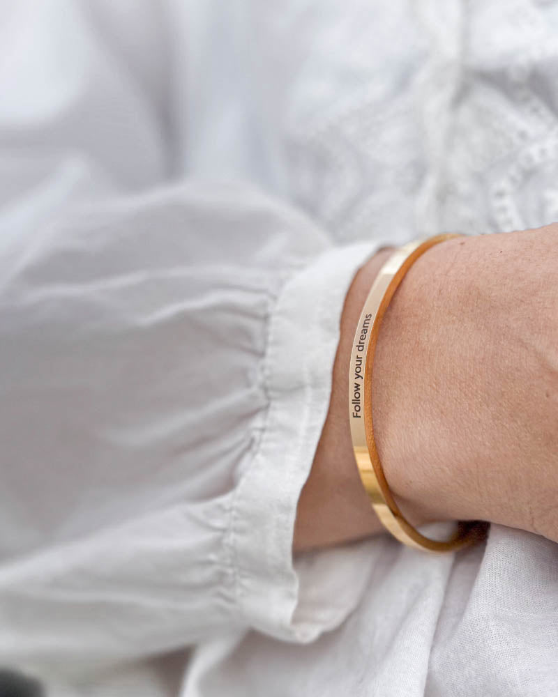 VENUS armbånd i guldbelagt stål med graveringen "Follow your dreams" til hvid bluse med pufærmer