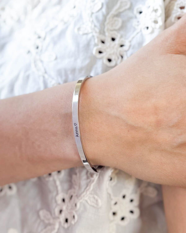 VENUS SCRIPT armbånd i sølvfarvet rustfrit stål med navnet "Anna" ♡ i håndskrift om håndleddet, hvid broderet bluse
