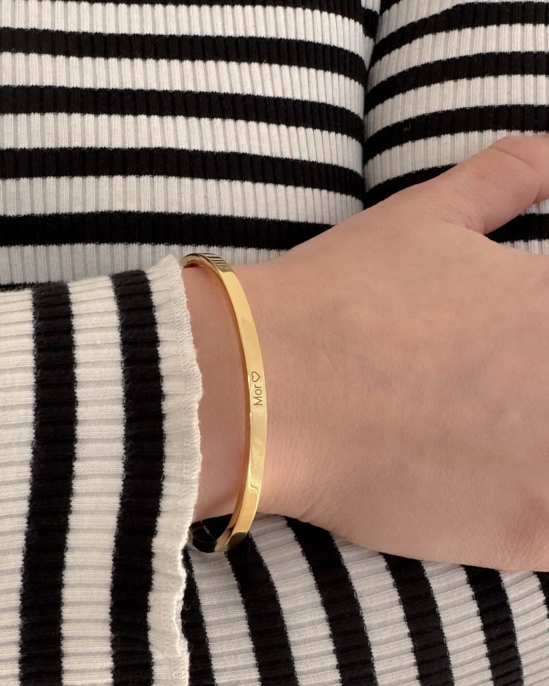 VENUS armbånd i guldbelagt stål med graveringen "Mor" ♡ om håndleddet, sort-hvid stribet strik